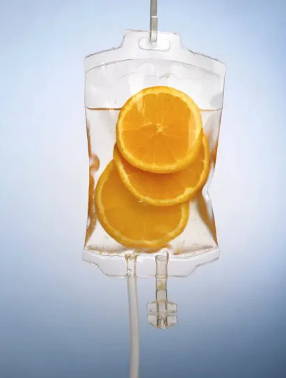 IV infusion bag filled with clear fluid and fresh orange slices