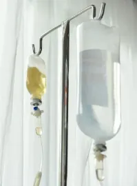 Intravenous infusion bag suspended on a stand in a bright treatment room
